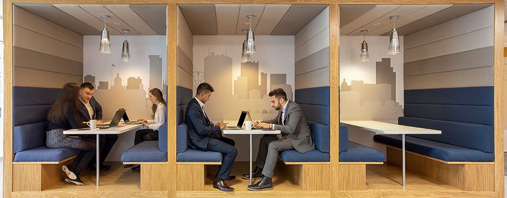 2 Men sat working in a co-working booth